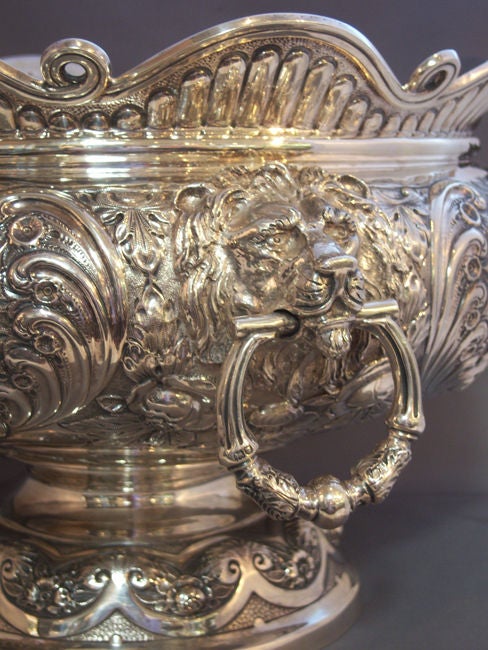 Exceptional sterling silver Armada pattern, large Montieth Bowl, with applied angelic mermaids and mermen with lion handles, flanked by floral repousse with central cartouches on each side. By Elkington & Co, 1906, London, England.