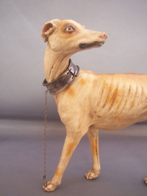 Wonderful Italian Art Deco Terra Cotta Greyhound, with glass eyes, silver collar and leash. Circa 1920s.