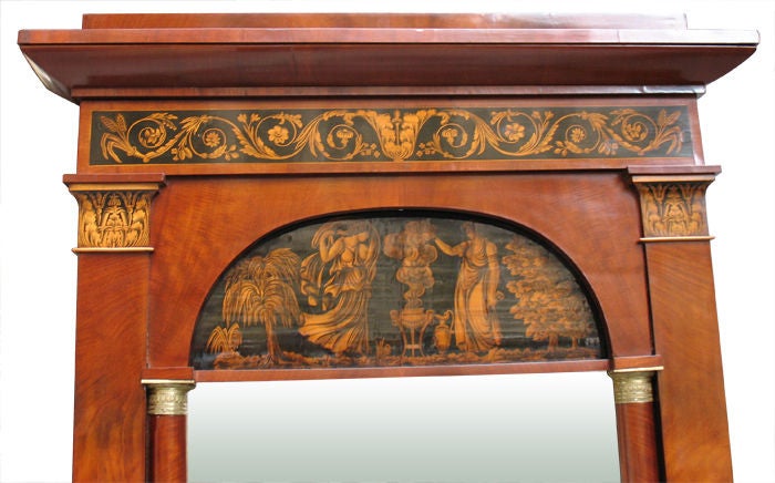 German Biedermeier hall mirror in mahogany on pine. Attributed to court cabinetmaker Phillip Carl Hildebrandt. Arched top, cornice and capitals with original pen works (Schwarzlotmalerei) including scrolled foliage as used in Normand's grotesque