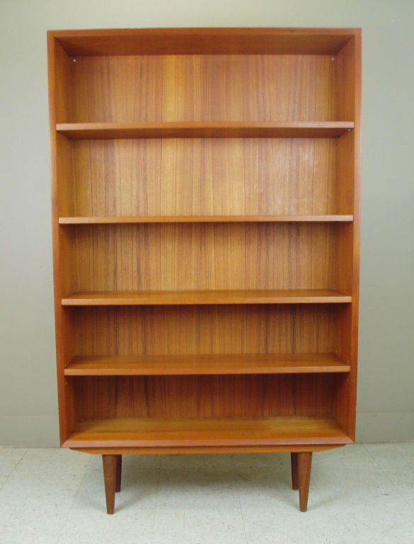 a very nice vintage Danish Teak Bookcase designed by Kofod Larsen. very nice details including a beveled edge and raised on tapered legs.
