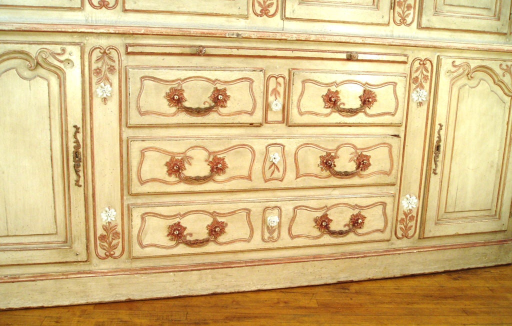 designed by Tony Duquette for a private residence in new york, this large French Provincial Style Buffet Deux Corps is hand painted in a wonderful palette of muted washed rose and cream and embellished with hand painted porcelain flowers. this