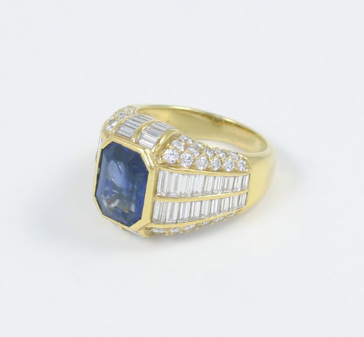 18K yellow gold emerald cut sapphire, baguette & round diamond ring <br />
1 sapphire approximately 4.00 ct.<br />
56 baguette diamonds 2.50 ct.<br />
52 round pave set diamonds 1.00 ct.