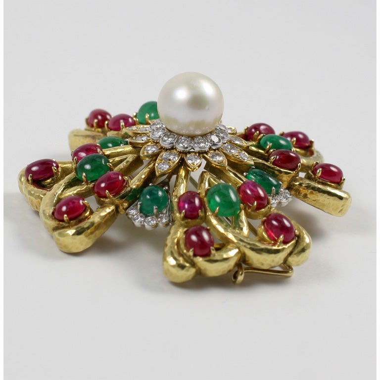 David Webb Maltese Cross, center set with a South Sea pearl surrounded by diamonds, cabochon emeralds and rubies, set in hammered gold and platinum. May be worn as a pin or pendant.  The pin has a platinum double prong clip, designed for easy wear.
