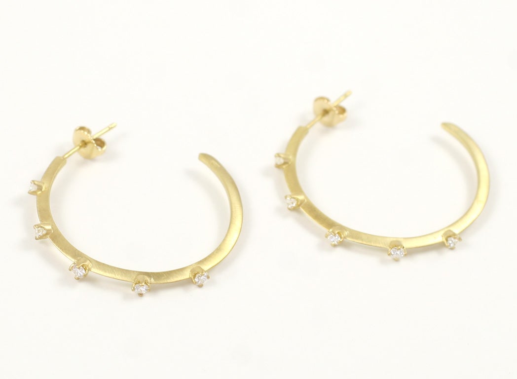 18K yellow gold matte finished, knife edged hoop earrings with prong set diamonds.<br />
10 round diamonds 0.70 ct.