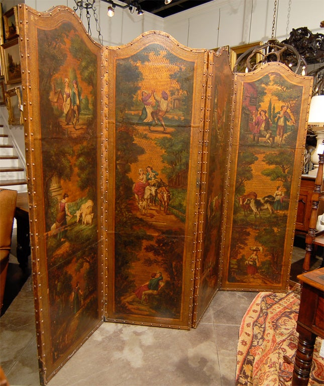 This delicate late 19th century English Victorian four-fold gilt leather screen is decorated with painted pastoral scenes bordered by brass nails and an embossed frame of vegetal motifs. Each panel features a crossbow-shaped top over a row of three