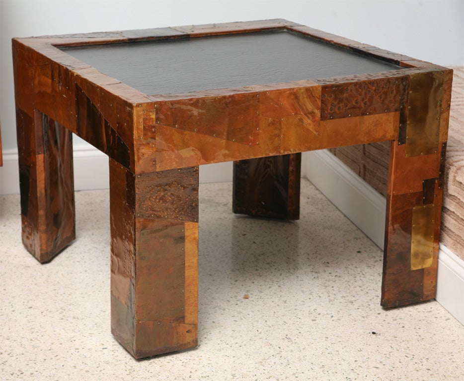 The slate top inset into a Parsons form table covered in strips and sheets of various metals.