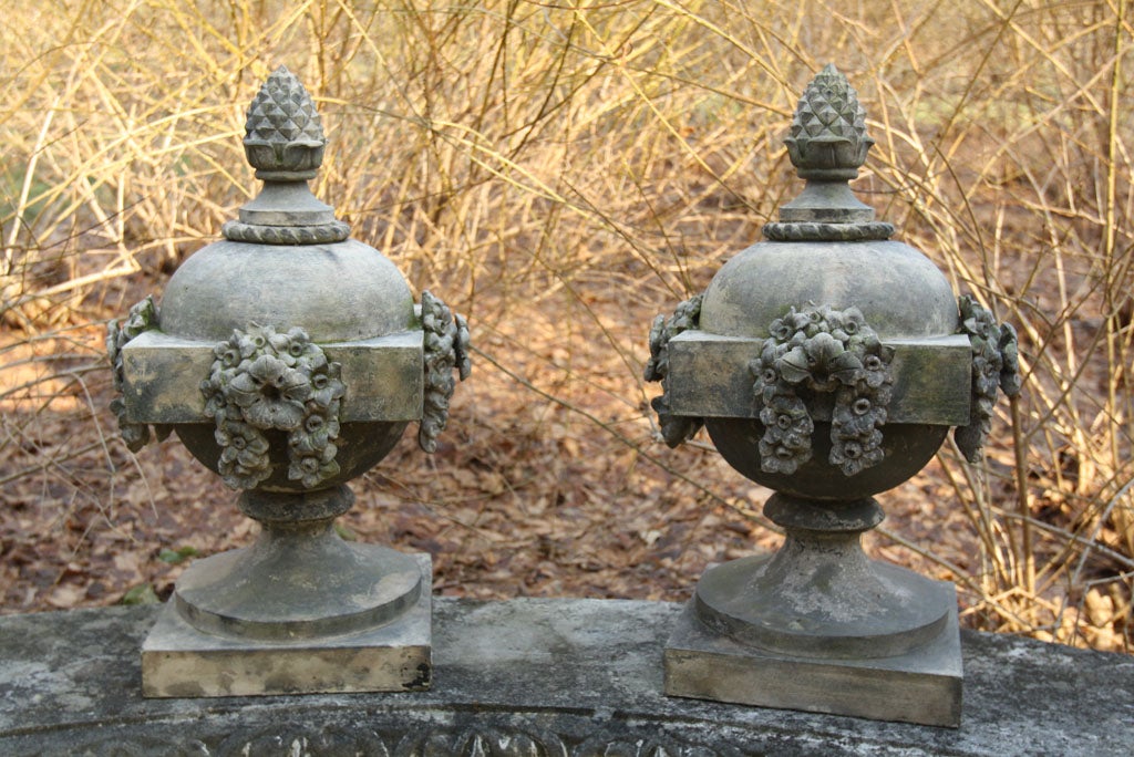 A very fine pair of blocked stoneware ball finials with pineapple terminals, floral blossoms and narcissus swags, one finial marked 