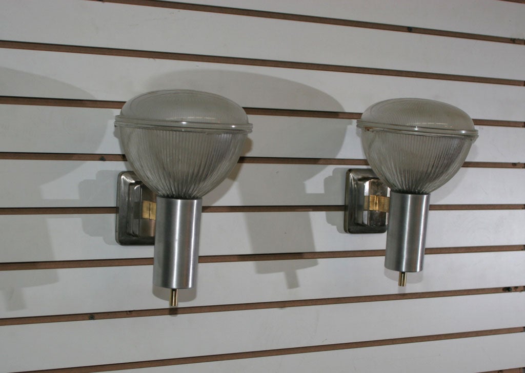 A pair of Milanese sconces in the style of Ignazio Gardella. Wall mounted metal structures with glass reflectors.