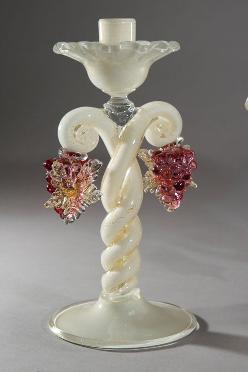 Hand blown three piece white centerpiece set icased to clear. Each piece is filled with gold leaf and embellished with hand blown figural bunches of grapes. One can only imagine the glass blower at work as he twisted the stems of each candlestick