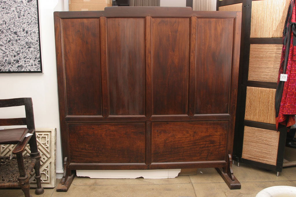 A Burmese teakwood screen with 4 stationary panels.  A handsome room divider or headboard.  72