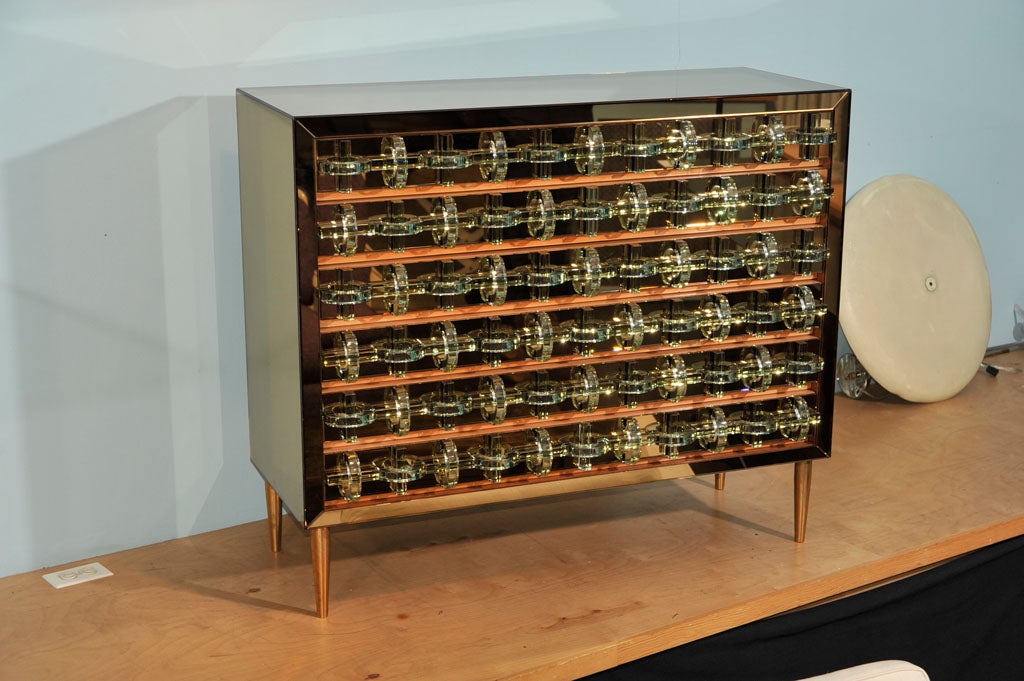 Amazing chest of drawers incorporating vintage San Gobain - champagne colored mirror, and contemporary glass elements, over a wood chest.  Solid brass cone feet. This is a beautiful and completely unique piece, unlike anything we've seen before.