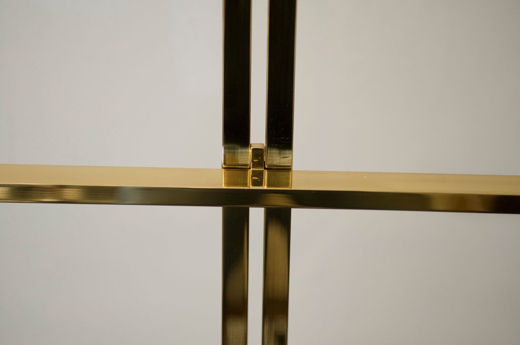 A stylish lacquered brass easel that easily adjusts to fit a variety of paintings.
