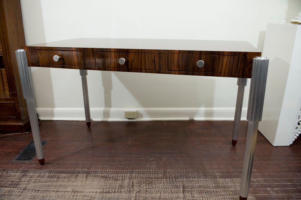 A sumptuous bench made rosewood veneered desk with aluminum cast legs.