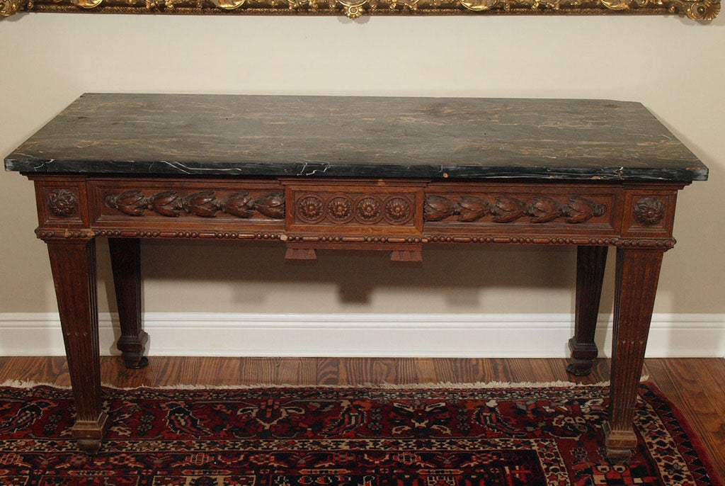 Mid 19th c Louis XVI console table of oak from the north of france. Black,gold, and white veined marble top on very well carved frieze and legs.