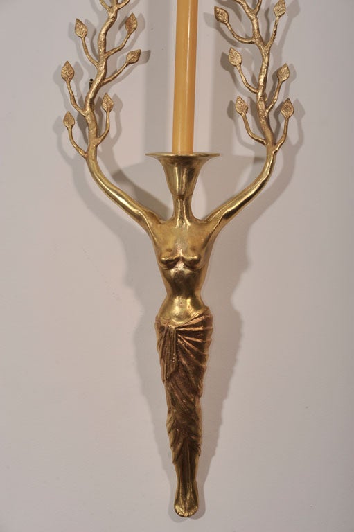 A pair of polished bronze candle sconces.