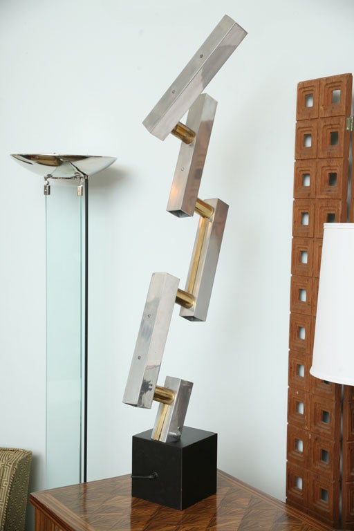 The aluminum and brass rods, movable, on an ebonised plinth.