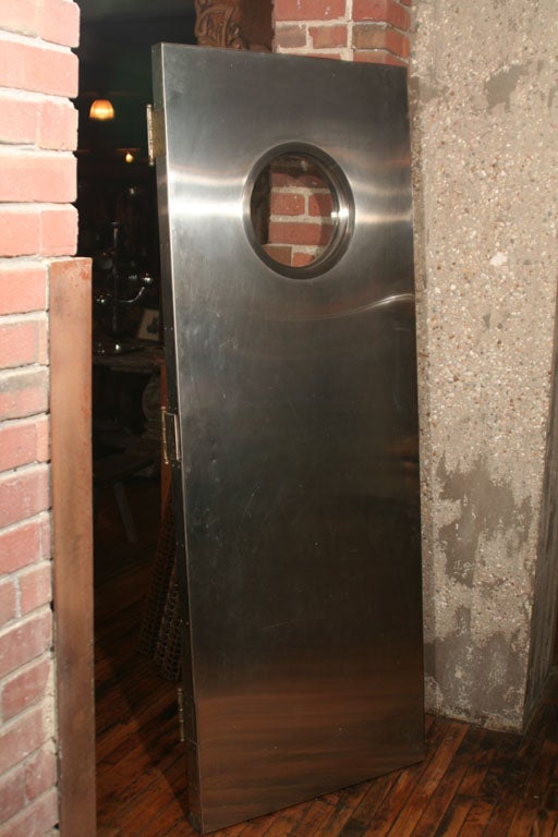 A stainless steel door with round window.