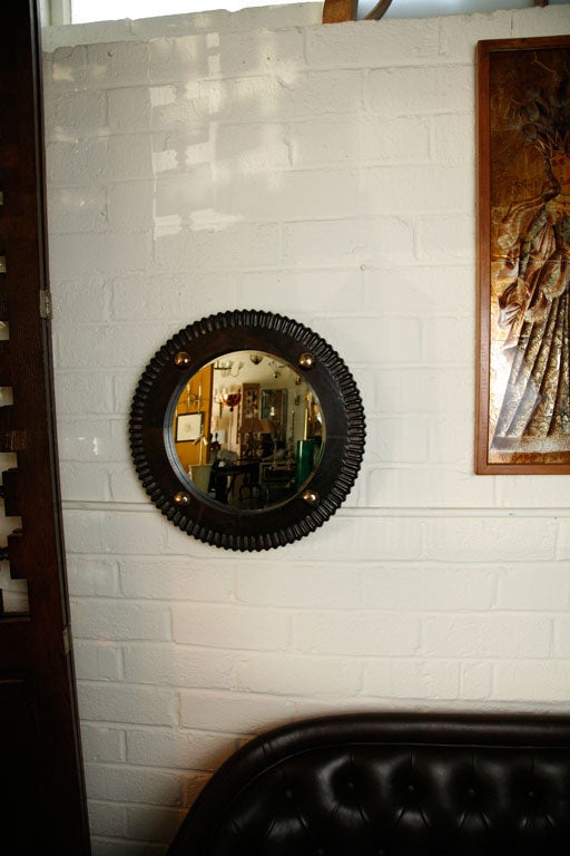 Paul Marra Gear style mirror finished in an ebony finish with brass nailheads, beveled mirror. By order.