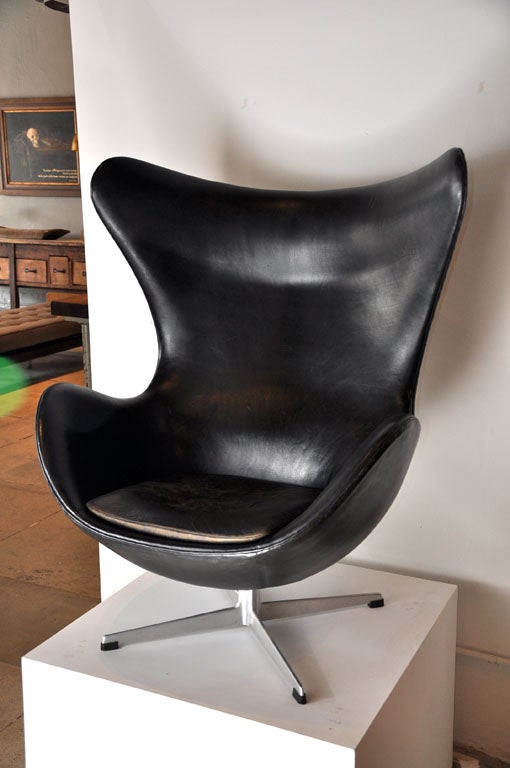 an early edition egg chair in original black leather with original cushion.