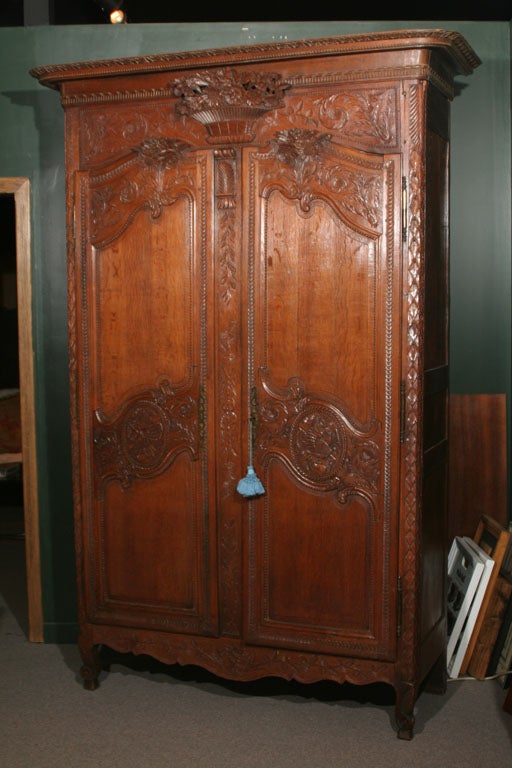 This fine Armoire has nicely carved feet rising into deeply carved stiles.  The apron, doors and top rail feature the stylistic carvings for which Normandy is famous.  The flowers of the  piece are exquisite and the whole is topped by a nicely