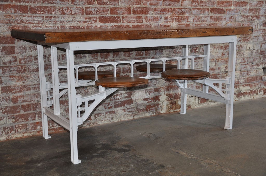 Vintage factory cafeteria table with four attached swing-out stools.  Please note that this table does need to be bolted to the floor or somehow counterbalanced.