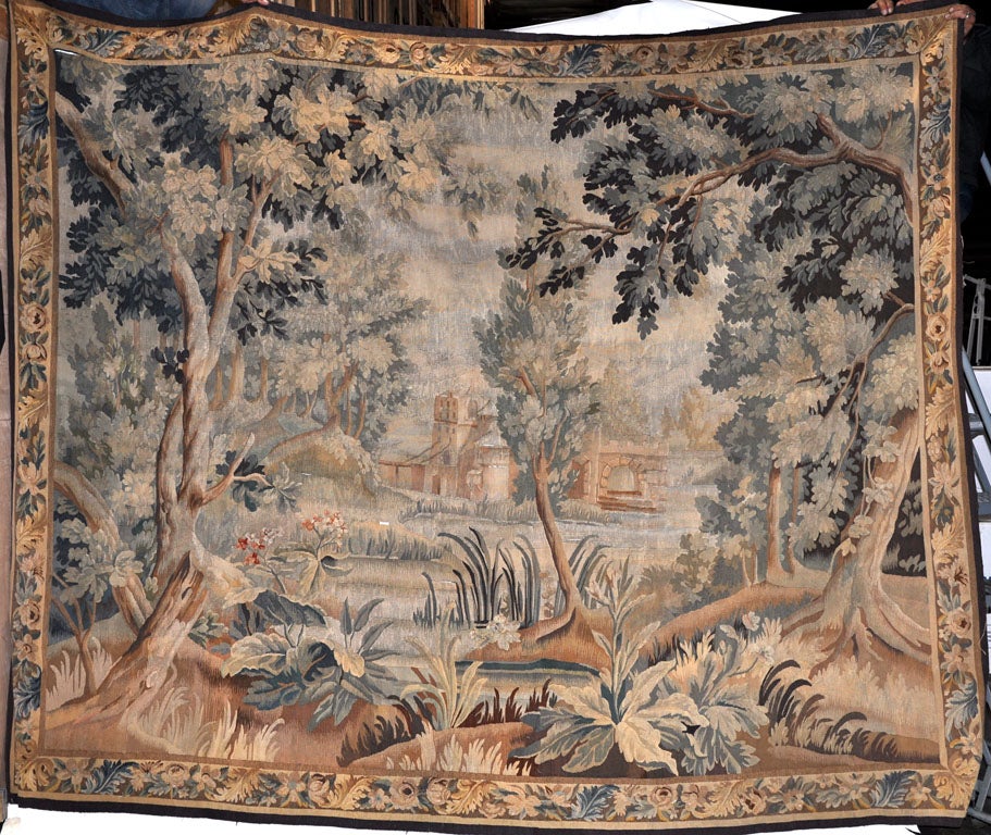 Beautiful French or Flemish Tapestry depicts a clearing in the forest. The rich green, dark blue and goldish brown colors of the yarns give this tapestry a rich patina that speaks of centuries of use.  Beautiful on a staircase or in a living room,