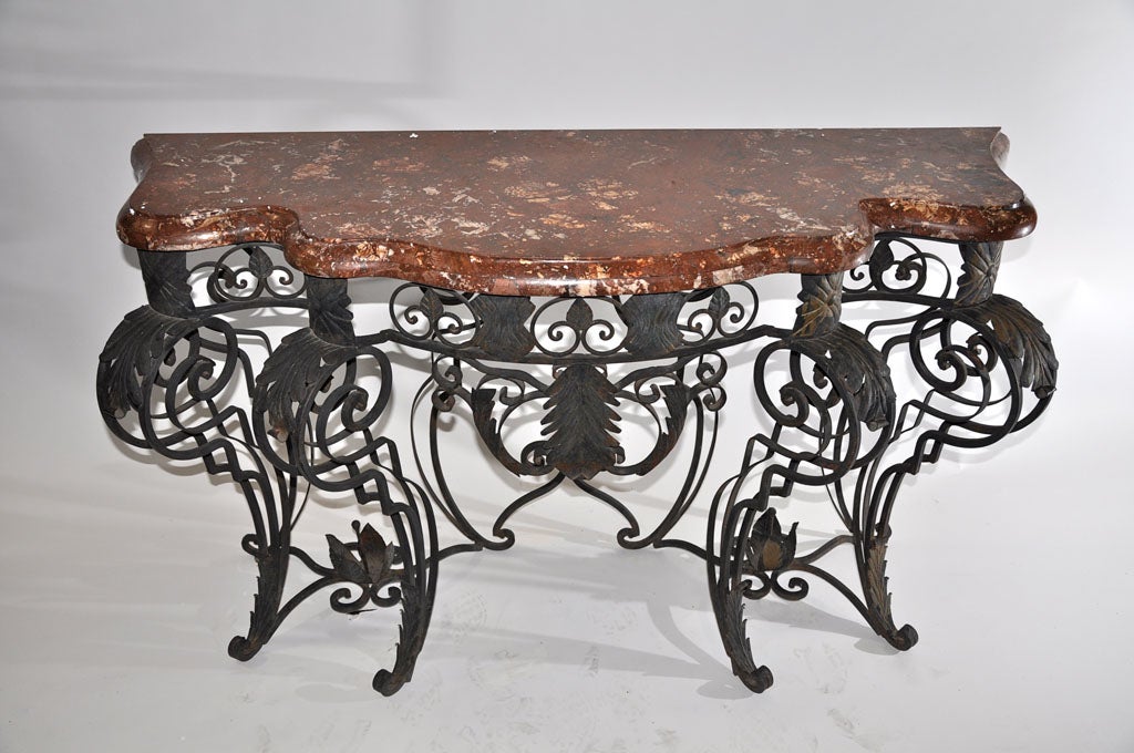 These beautifully scrolled wrought iron table bases have just the right amount of weight to balance with the rich red marble console tops.  This pair of consoles are the perfect compliment for a living or dining room.