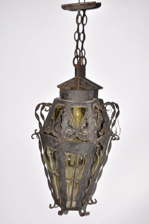 A wrought iron and glass hanging lantern.