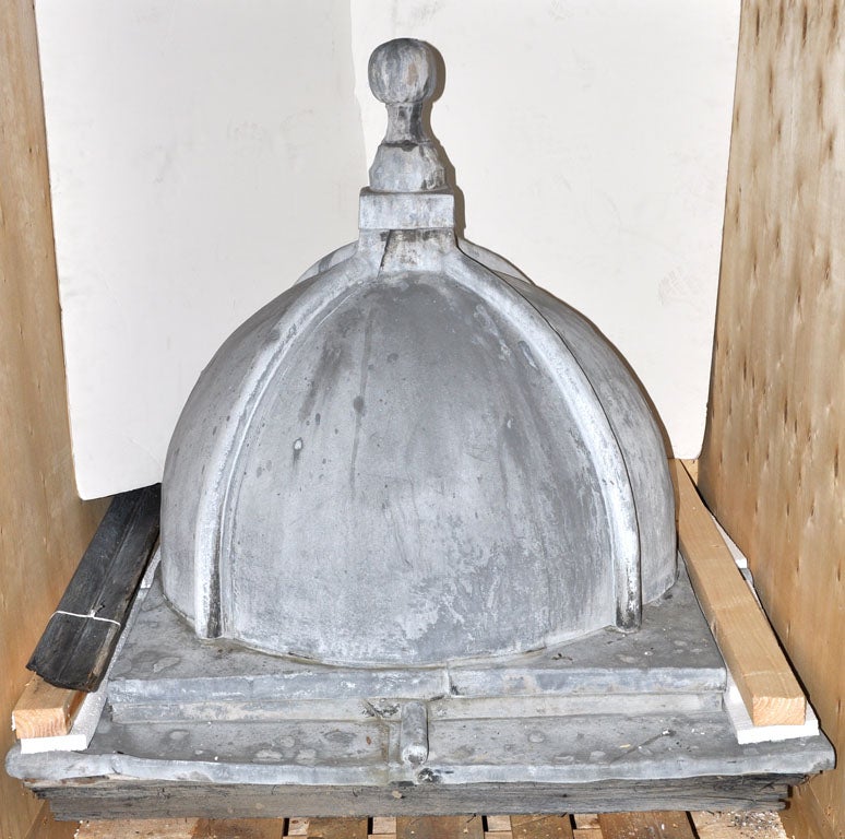 A 20th century lead cupola with spherical finial above the ribbed dome and square base.