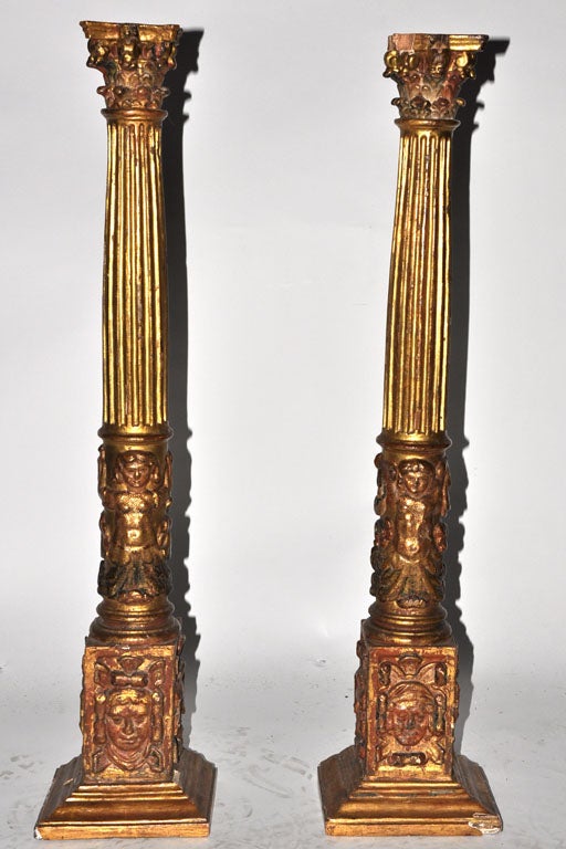 A carved gilt-wood decorative column with Corinthian capital and masks at base. 