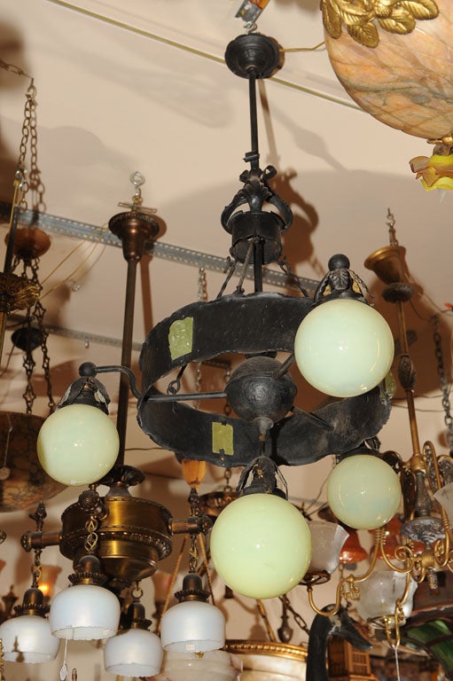 Handsome ring-style fixture has original vaseline glass globes with a larger center globe. The ring itself is accentuated with vaseline glass chunk jewels. All this makes for a very harmonious package. A very unusual and desirable look for any house.