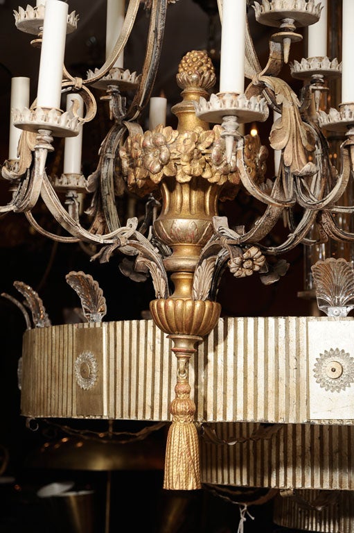 A Renaissance Revival cage form chandelier, iron frame and carved wood vase shaped center, the center having floral motif details, gadrooned cap underside and trompe l'oeil tassel secured to bottom.  Attributed to Edward F. Caldwell & Co, New York 