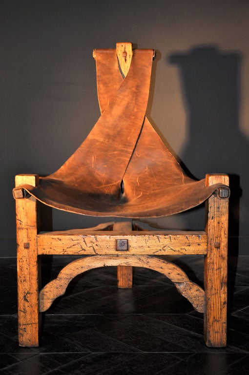 3 LEGGED OAK AND LEATHER CHAIR WITH SLUNG LEATHER SEAT AND SCROLLED DETAIL