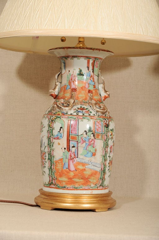 Pair of Chinese Famille Rose Porcelain Vases, Late 19th / Early 20th Century. Newly Wired as Lamps to U.S. Electrical Code with Double Swivel Light Cluster and Adjustable Finials; Mounted on Giltwood Bases.  <br />
<br />
28 inches high