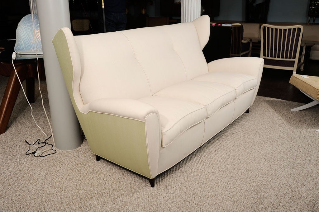 Italian two-tone sofa upholstered in beige and light green.  Winged back and wooden cone feet.