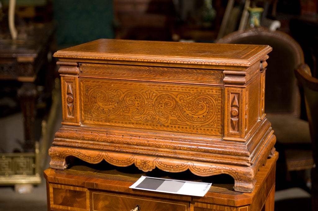 Finely carved miniature pine blanket box with intricate folk art pattern.