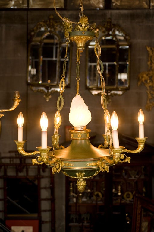 Green tole and gilt bronze 6 light Empire style chandelier with central frosted glass flame form finial shade.