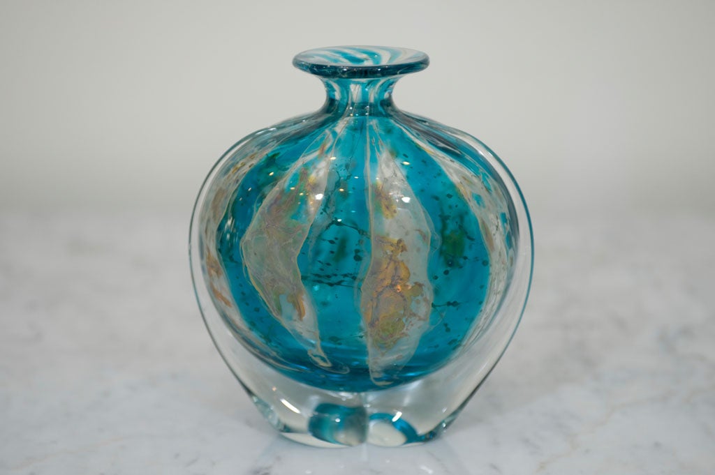 A stunning blue and clear glass vase with milky white and golden<br />
brown accents.