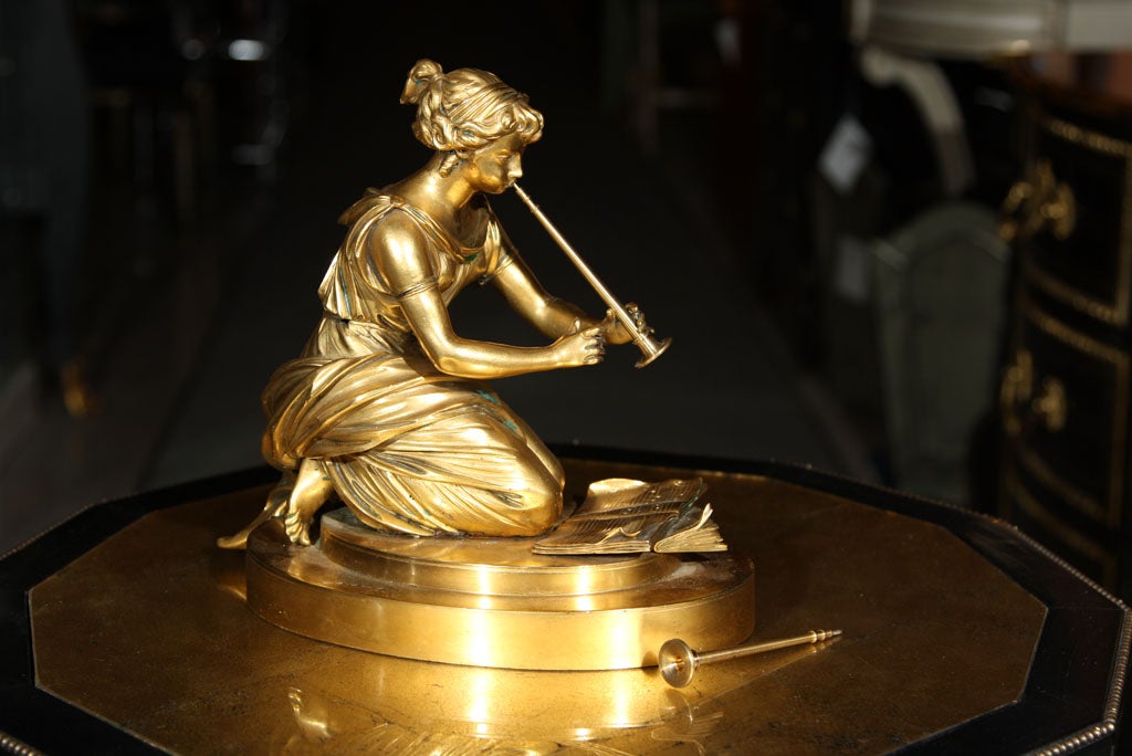 Sculpture en bronze représentant une dame avec un instrument de musique.