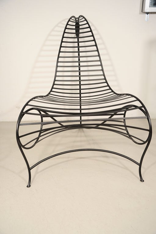 This wrought iron chair seduces with it's graceful curves. A very comfortable chair for an outside space or loft.