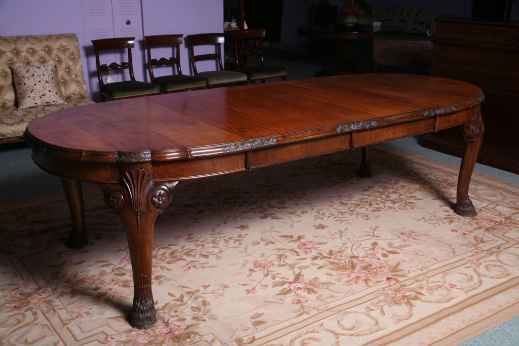 An English Walnut Extending Dining Table with horse hoof feet.