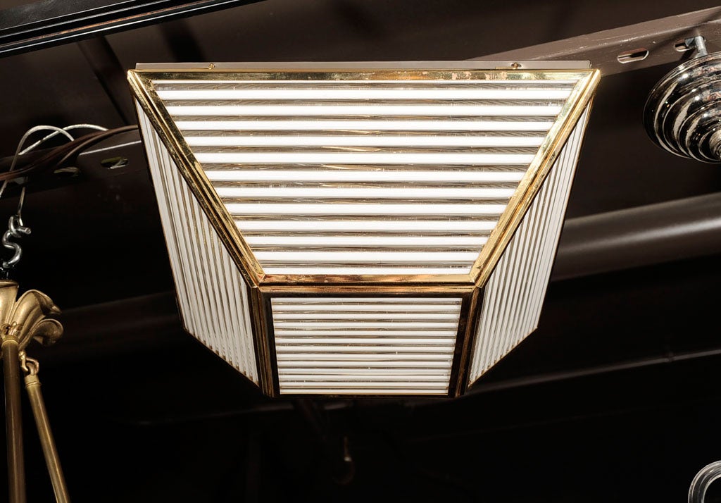 Trapezoid shaped flush mount<br />
chandelier with antique brass<br />
frame and fluted plexiglass<br />
sides.
