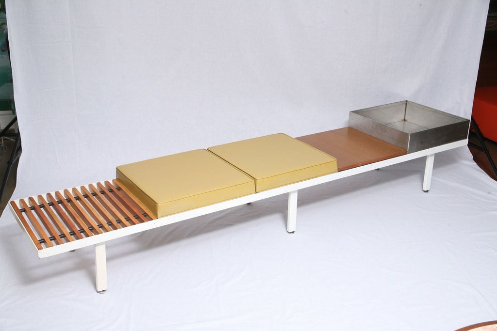 This is a rare custom bench which includes 1 slatted and 1 solid surface, two seats covered in mustard leatherette, and a stainless steel planter. These features are rarely seen comprised together on one seating unit and can be switched for various