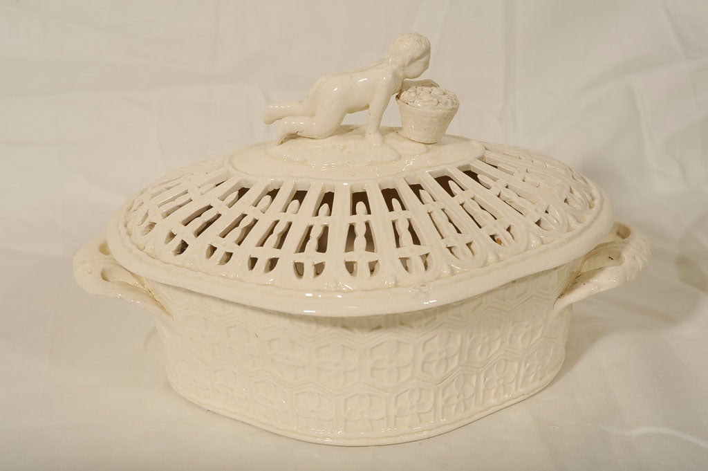 An outstanding pair of 18th century pierced creamware chestnut baskets.
Oval with straight sides moulded with a quatrefoil pattern within hexagonal panels, each basket has a pair of pierced foliate handles. The lids are pierced and provided with a
