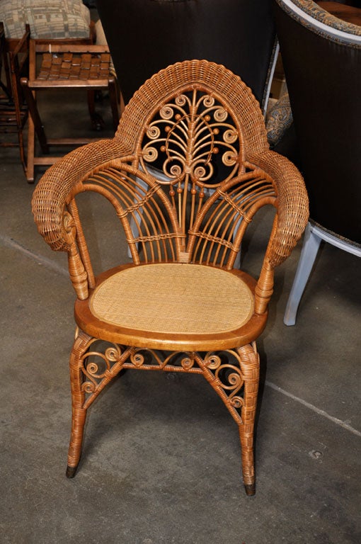 This American wicker arm chair, circa 1890, is thought to be Heywood Wakefield. The chair was possibly used in a photographers studio and has a profusion of decorative elements. It is a very good example from the period.