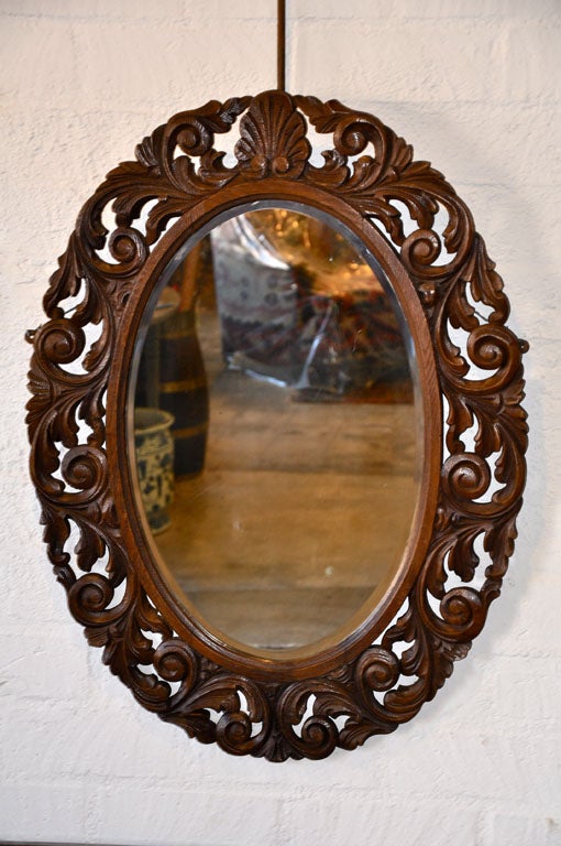 This English oval framed mirror, circa 1890, has a wide and crisply carved frame. Being 34