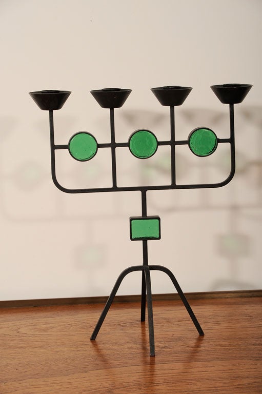 Two iron candlesticks, one with amber, one with green glass inserts. Designed by Erik Hoglund for Ystad, produced 1950's.  Priced individually.
