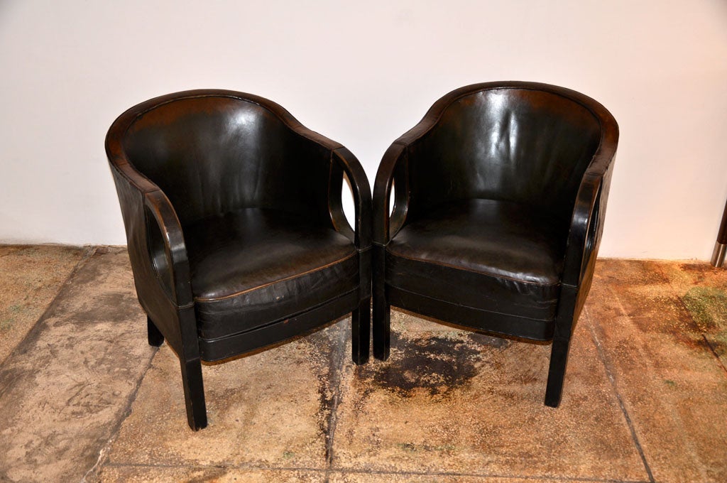 Stunning pair of small arm chairs with rounded backs and curved painted wood arms.  Leather has tones of brown and dark green with beautifully aged patina.  Cushions are filled with horse hair.  Seat height is 18.5