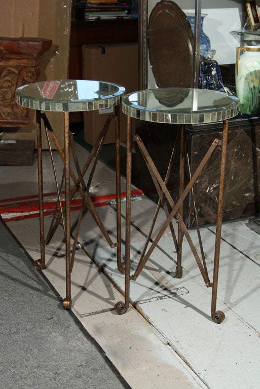 Decorative patinated metal stand on scrolled feet with circular mirrored tops.