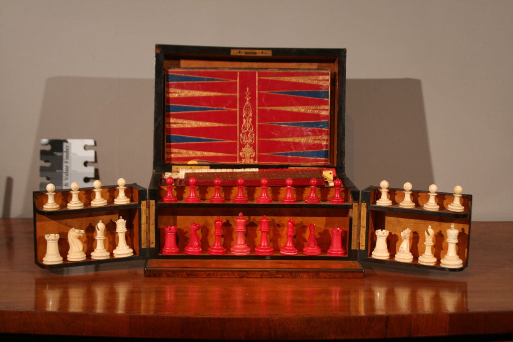 AN ANTIQUE NGLISH, ROYAL BOX OF GAMES IN A BURL WALNUT BOX OPENING TO REVEAL A SATINWOOD INTERIOR HOUSING CHESS, BACKGAMMON, CRIBBAGE, DOMONOES, CARDS, AND STEEPLE CHASE.<br />
DATING CIRCA 1860